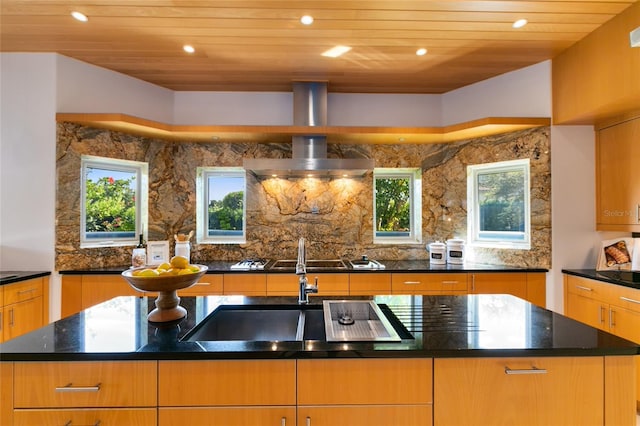 kitchen featuring a center island with sink, wooden ceiling, sink, and dark stone counters