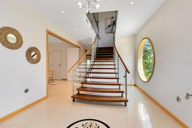 stairway with tile patterned flooring and a notable chandelier