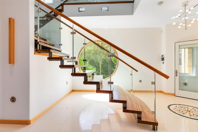 stairway featuring tile patterned floors, plenty of natural light, and an inviting chandelier