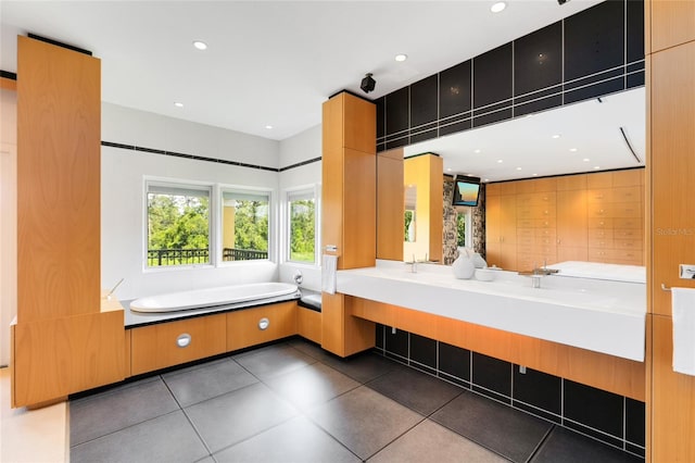 bathroom featuring tile patterned floors, a washtub, and vanity