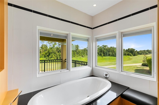 bathroom featuring a tub to relax in and tile walls