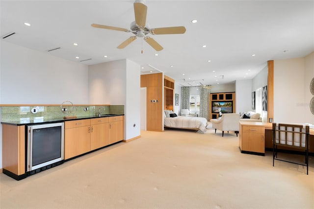 kitchen with light carpet, light brown cabinets, ceiling fan, and sink