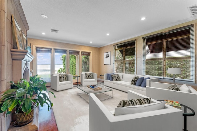 living room with crown molding, a textured ceiling, and light wood-type flooring