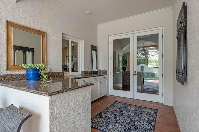 doorway to outside featuring french doors, tile patterned floors, and sink