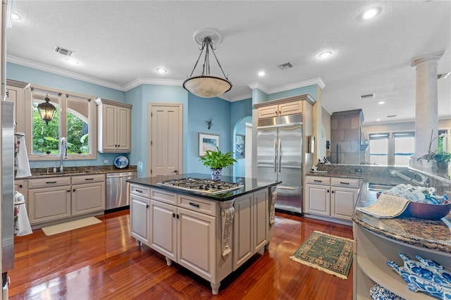 kitchen with pendant lighting, sink, stainless steel appliances, and a center island