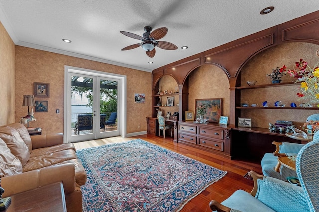 living room with ornamental molding, wood-type flooring, built in features, and a textured ceiling