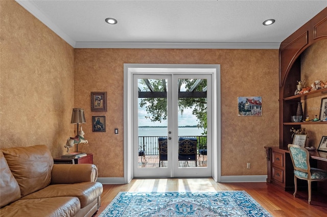 entryway with french doors, ornamental molding, and light hardwood / wood-style flooring