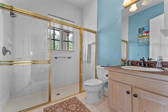 bathroom featuring walk in shower, vanity, toilet, and tile patterned flooring