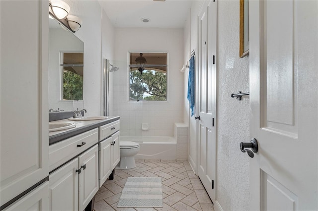 full bathroom with vanity, tiled shower / bath combo, and toilet