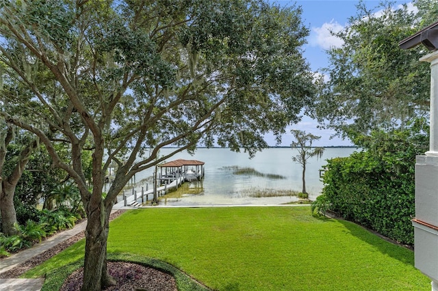 view of yard with a water view and a boat dock