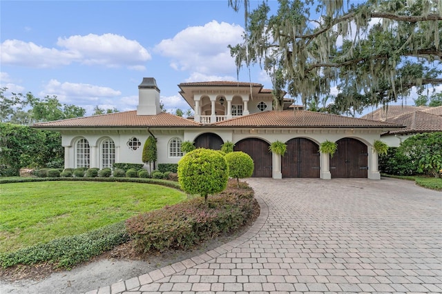 mediterranean / spanish-style home with a garage and a front yard