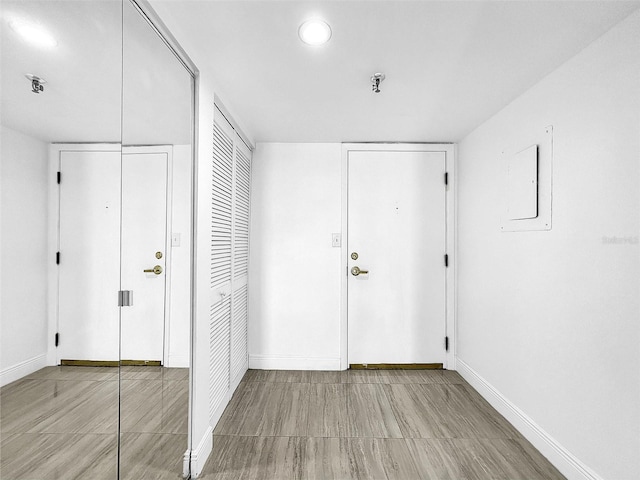 foyer with electric panel and baseboards