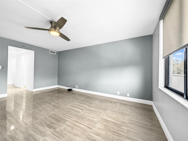 unfurnished room with visible vents, baseboards, and ceiling fan