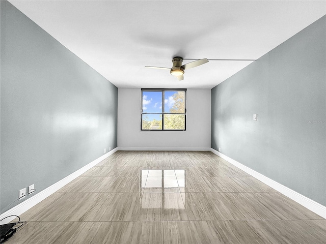 spare room featuring ceiling fan and baseboards