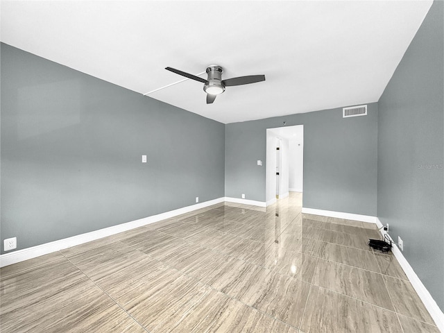 spare room with visible vents, a ceiling fan, and baseboards