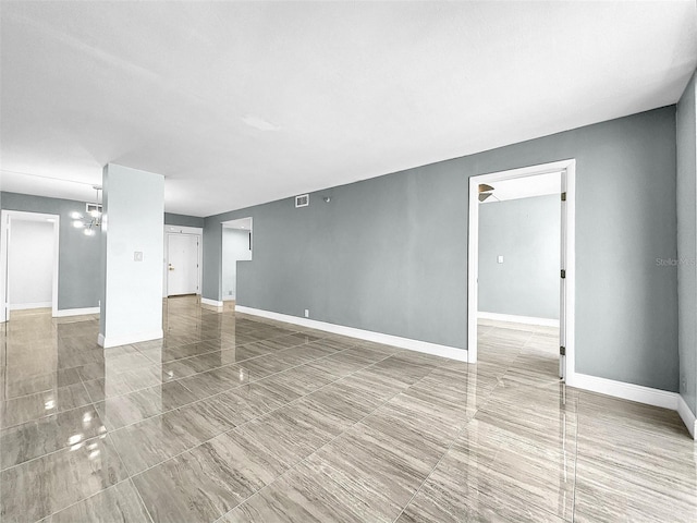 interior space featuring baseboards, visible vents, and a chandelier