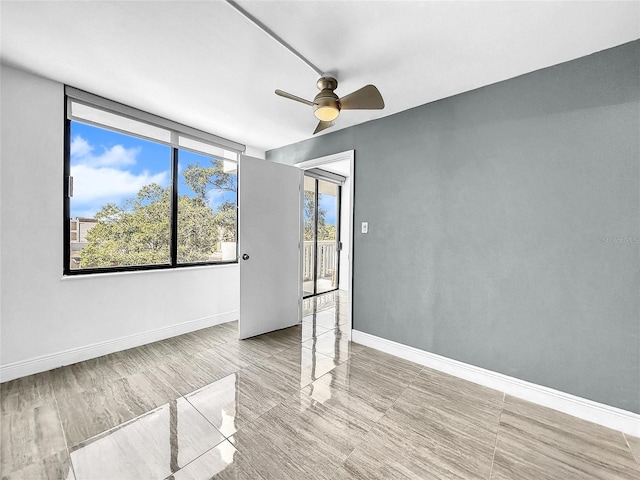 unfurnished room featuring a ceiling fan and baseboards