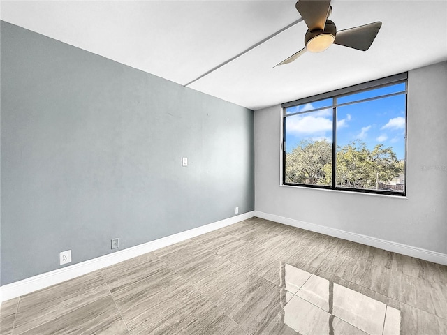 spare room with baseboards and ceiling fan