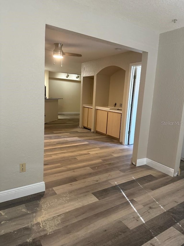 hall with a textured ceiling and dark hardwood / wood-style flooring