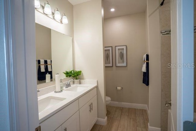 bathroom featuring wood-type flooring, toilet, and vanity