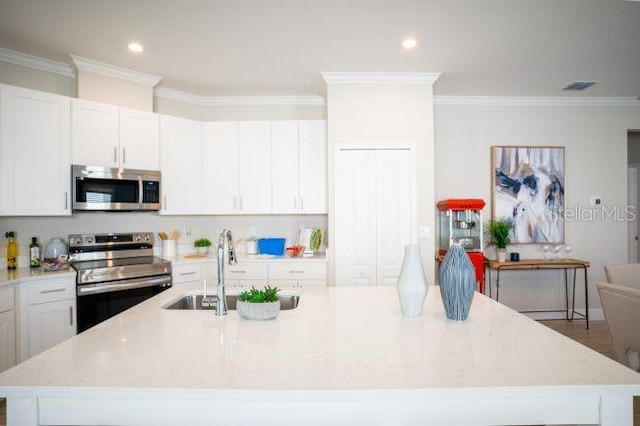 kitchen featuring light stone counters, a center island with sink, and appliances with stainless steel finishes