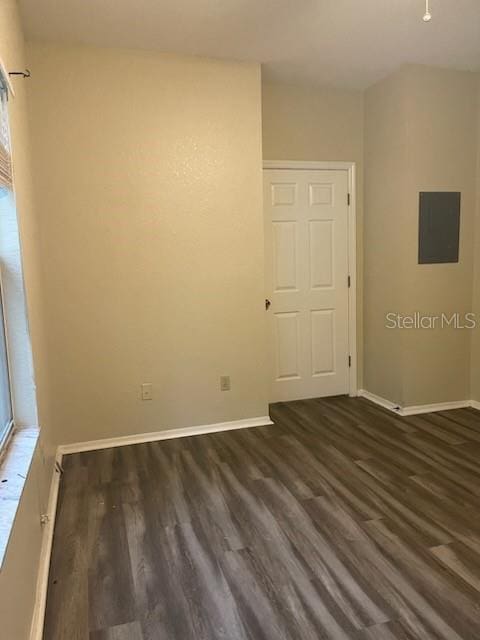 spare room with dark wood-type flooring and electric panel