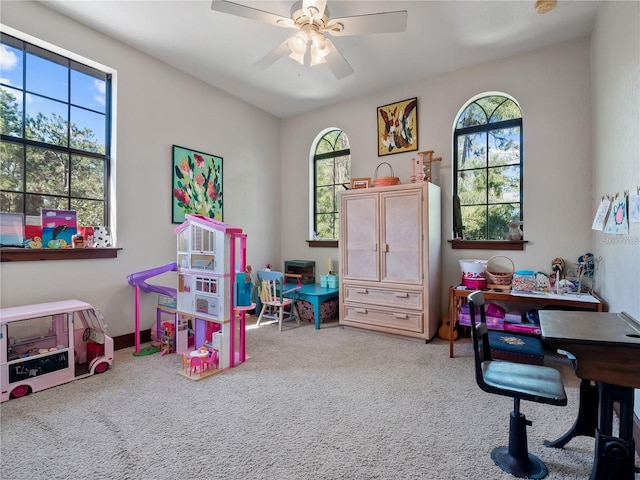 game room featuring carpet flooring, ceiling fan, and a wealth of natural light