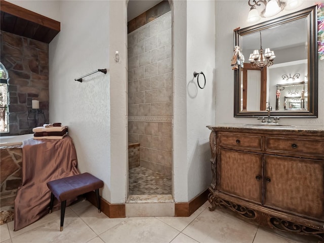 bathroom featuring a tile shower, tile patterned floors, vanity, and a notable chandelier