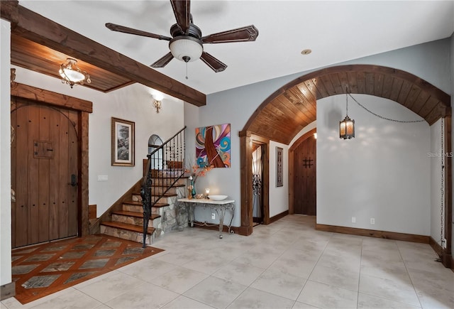 foyer entrance featuring ceiling fan, beamed ceiling, and light tile patterned floors