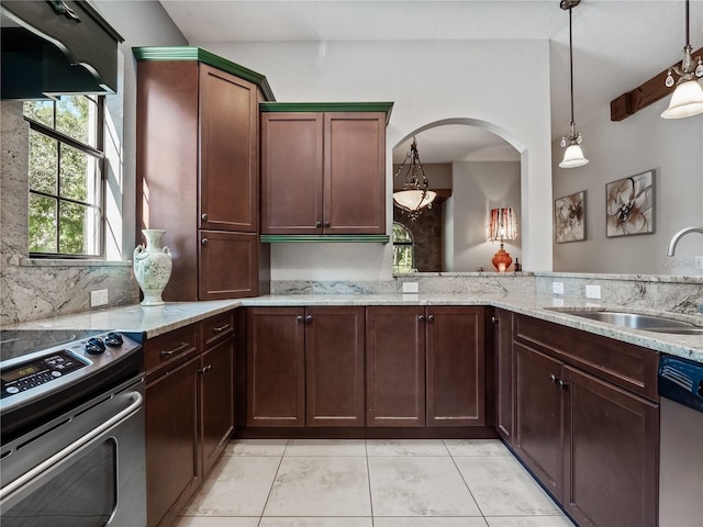 kitchen with light stone counters, stainless steel appliances, sink, decorative light fixtures, and light tile patterned flooring