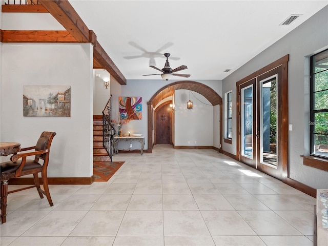 foyer entrance with french doors, light tile patterned floors, ceiling fan, and a healthy amount of sunlight