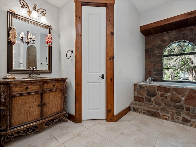 bathroom with tile patterned flooring, vanity, a bath, and an inviting chandelier