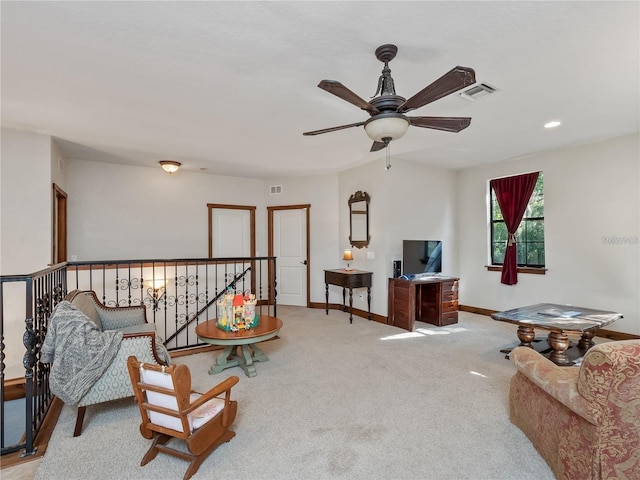 living area with light colored carpet and ceiling fan