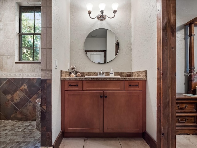 bathroom with vanity, a shower, and tile walls