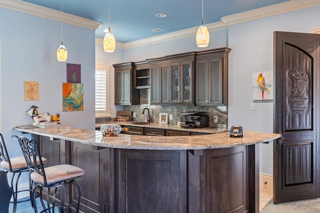 bar featuring sink, hanging light fixtures, tasteful backsplash, and light stone counters