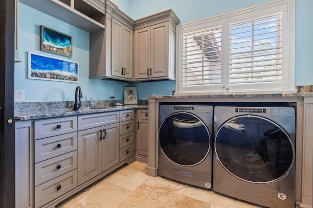 washroom featuring light tile flooring, cabinets, washing machine and clothes dryer, and sink