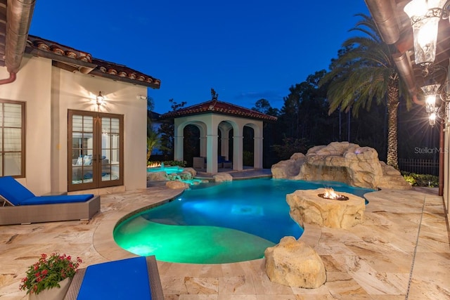 pool at twilight featuring french doors and a patio