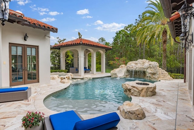 view of swimming pool with french doors, pool water feature, and a patio