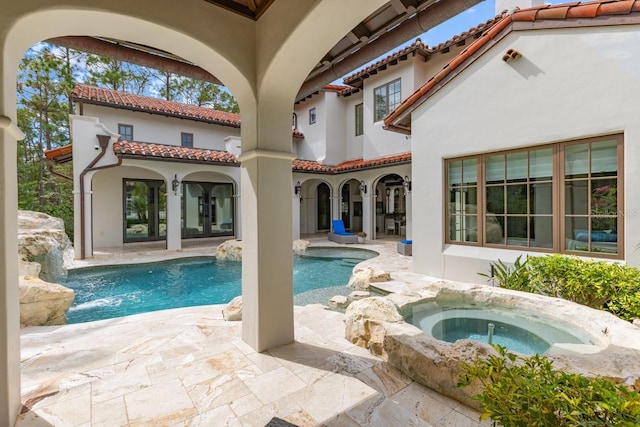 view of swimming pool featuring a patio, an in ground hot tub, pool water feature, and french doors