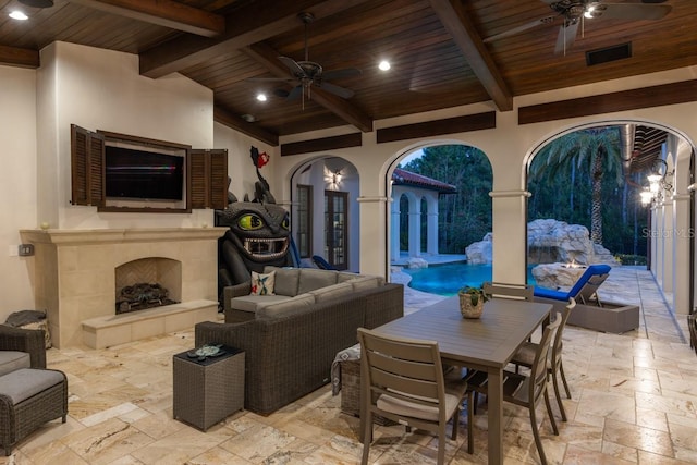 view of terrace featuring an outdoor living space with a fireplace and ceiling fan