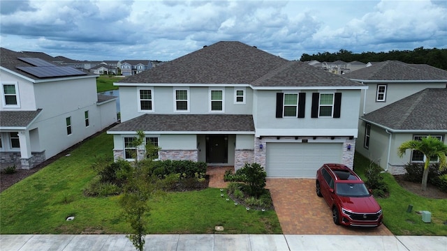 view of front of home featuring solar panels, a front lawn, and a garage