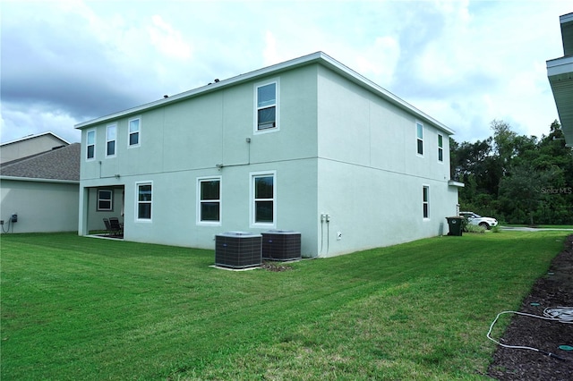 rear view of house with a yard and central air condition unit