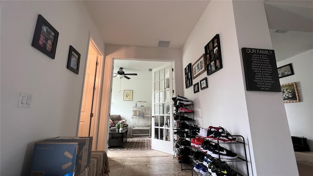 hall featuring light tile flooring and french doors