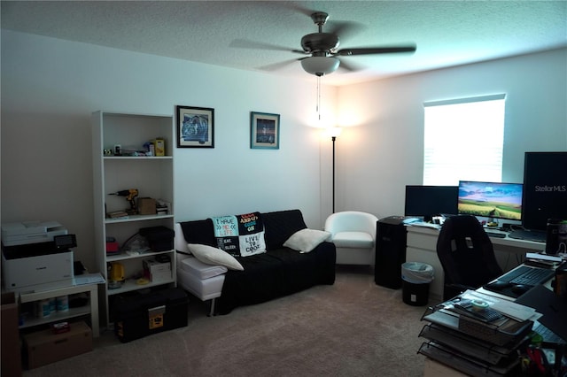 carpeted home office featuring a textured ceiling and ceiling fan