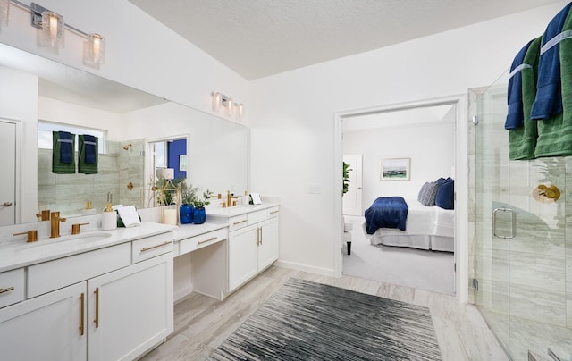 bathroom featuring dual bowl vanity and an enclosed shower