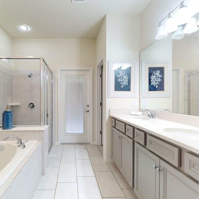 bathroom featuring dual bowl vanity, tile flooring, and plus walk in shower