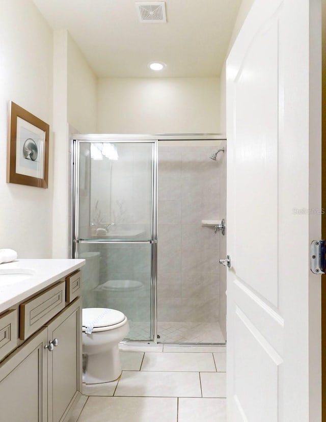 bathroom with vanity, tile flooring, toilet, and walk in shower