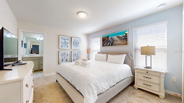 bedroom featuring connected bathroom and light colored carpet