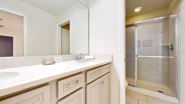 bathroom featuring dual bowl vanity, tile flooring, and a shower with shower door