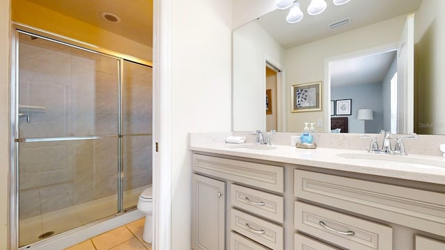 bathroom featuring walk in shower, tile flooring, double vanity, and toilet